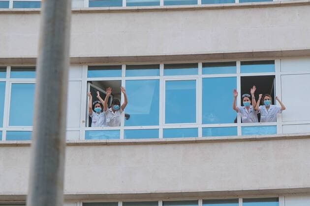Medical staff from the Fundacion Jimenez Diaz Hospital gestures as neighbours applaud from their balconies in support of healthcare workers, during the coronavirus disease COVID 19 outbreak in Madrid, Spain April 13, 2020 Cordon Press