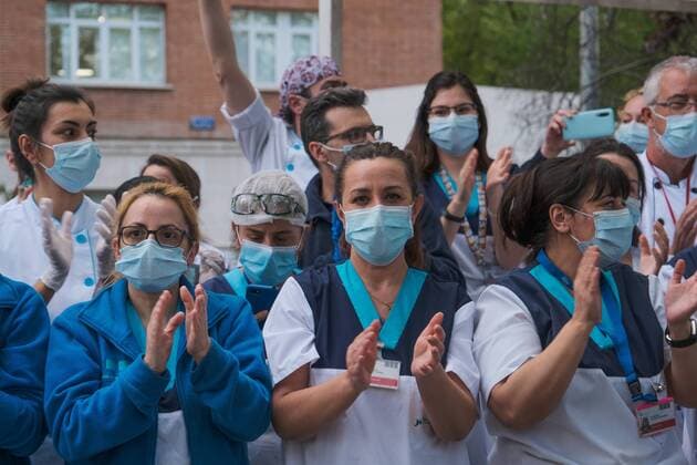 Medical staff from the Fundacion Jimenez Diaz Hospital gestures as neighbours applaud from their balconies in support of healthcare workers, during the coronavirus disease COVID 19 outbreak in Madrid, Spain April 13, 2020 Cordon Press