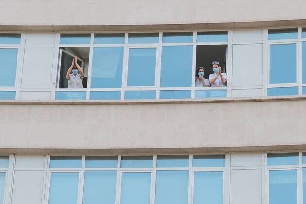 Medical staff from the Fundacion Jimenez Diaz Hospital gestures as neighbours applaud from their balconies in support of healthcare workers, during the coronavirus disease COVID 19 outbreak in Madrid, Spain April 13, 2020 Cordon Press