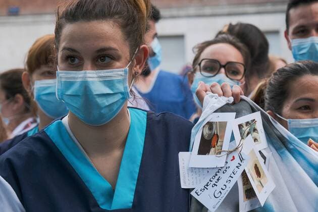 Medical staff from the Fundacion Jimenez Diaz Hospital gestures as neighbours applaud from their balconies in support of healthcare workers, during the coronavirus disease COVID 19 outbreak in Madrid, Spain April 13, 2020 Cordon Press