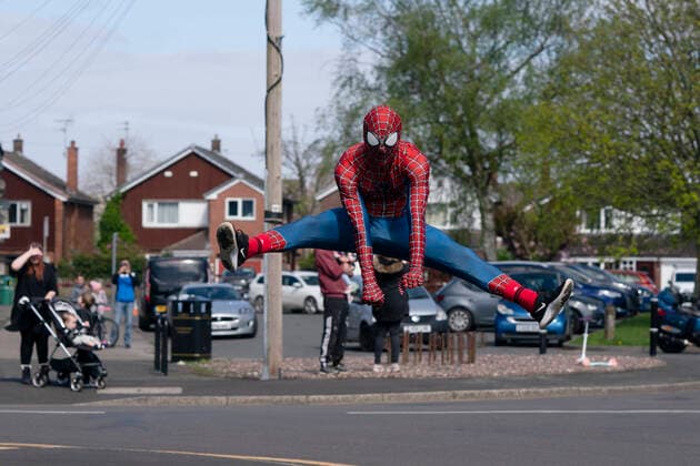 (200414) -- MANCHESTER, April 14, 2020 (Xinhua) -- Jason Baird, who runs a martial arts academy in South Manchester, dressed up as Spider-Man, entertains the public amid the COVID-19 outbreak in Manchester, Britain on April 13, 2020. (Photo by Jon Super Xinhua) BRITAIN-MANCHESTER-COVID-19-SPIDER-MAN 