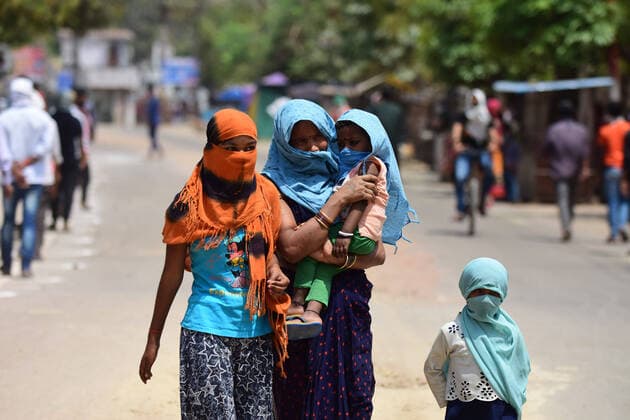 April 14, 2020, Prayagraj, Uttar Pradesh, India: Prayagraj: A Migratory worker along with her child cover their face with fabric arrive take free food outside Ishwar Sharan college community kitchen during a nationwide lockdown government-imposed nationwide lockdown as a preventive measure against the COVID-19 coronavirus, in Allahabad on Tuesday, April 14, 2020. Prayagraj India - ZUMAv115 20200414_zap_v115_011 Copyright: xPrabhatxKumarxVermax
