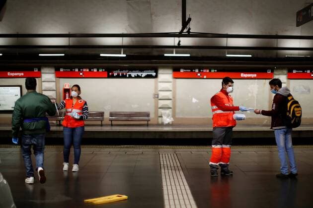 A Red Cross members give masks to commuters at a subway station in Barcelona, northeastern Spain, 14 April 2020. Authorities will deliver some 10 million mask in Spain until next 15 April amid coronavirus outbreak. Coronavirus crisis !ACHTUNG: NUR REDAKTIONELLE NUTZUNG!  Copyright: xMartaxPerezx GRAFCAT4839 20200414-637224558201034276