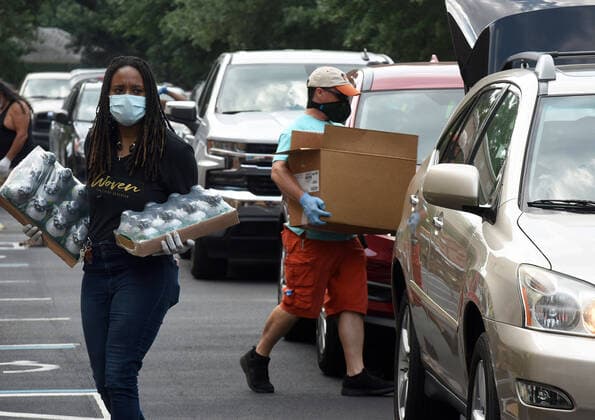 April 13, 2020, Orlando, Florida, United States: Volunteers from Church in the Son place food from the Second Harvest Food Bank of Central Florida into the cars of needy families at a drive-thru event..The numbers of people seeking food assistance in the Orlando area have risen sharply due to job losses caused by the coronavirus pandemic, thereby placing an extra burden on local food pantries. Orlando United States - ZUMAs197 20200413_zaa_s197_293 Copyright: xPaulxHennessyx