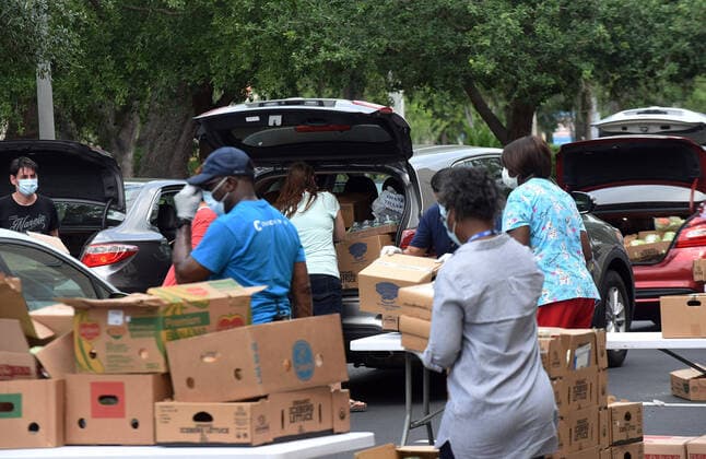 April 13, 2020, Orlando, Florida, United States: Volunteers from Church in the Son place food from the Second Harvest Food Bank of Central Florida into the cars of needy families at a drive-thru event..The numbers of people seeking food assistance in the Orlando area have risen sharply due to job losses caused by the coronavirus pandemic, thereby placing an extra burden on local food pantries. Orlando United States - ZUMAs197 20200413_zaa_s197_299 Copyright: xPaulxHennessyx
