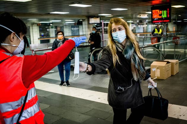 April 14, 2020, Barcelona, Catalonia, Spain: A Red Cross volunteer distributes protective face masks among commuters at Catalunya station in Barcelona. Thousands of people are returning to work after the Spanish government has lift the strictest measures of coronavirus confinement. Barcelona Spain - ZUMAb137 20200414_zap_b137_006 Copyright: xJordixBoixareux