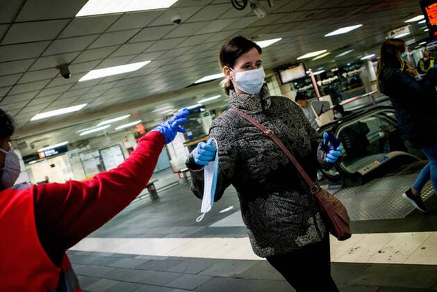 April 14, 2020, Barcelona, Catalonia, Spain: A Red Cross volunteer distributes protective face masks among commuters at Catalunya station in Barcelona. Thousands of people are returning to work after the Spanish government has lift the strictest measures of coronavirus confinement. Barcelona Spain - ZUMAb137 20200414_zap_b137_008 Copyright: xJordixBoixareux