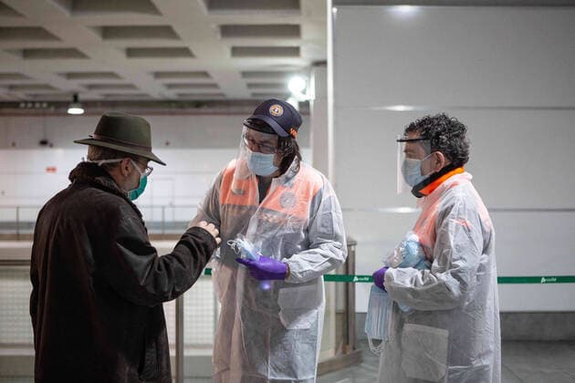 April 14, 2020, Girona, Spain: Spanish Civil Protection members distribute a face mask to a man as a preventive measure against the spread of Coronavirus (COVID-19) at the Girona railway station..The Spanish government reestablishes non-essential jobs in Catalonia after 31 days of confinement. More than 1,700,000 people return to work. Civil protection and police officers distribute masks at train and bus stations to prevent the spread of Covid-19 from increasing. Girona Spain - ZUMAs197 20200414_zaa_s197_032 Copyright: xMartixNavarrox