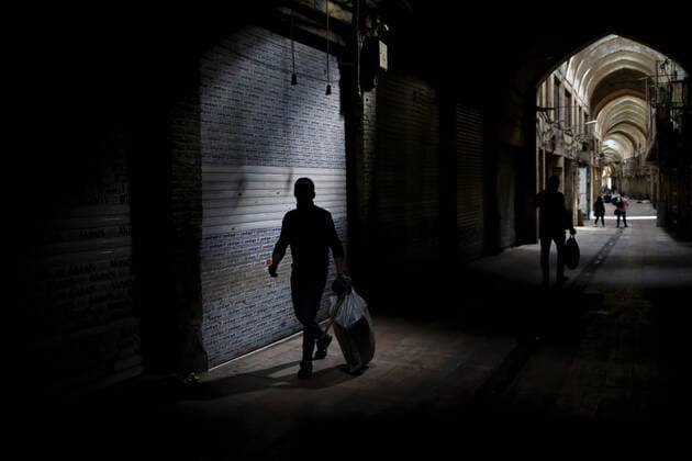 (200414) -- TEHRAN, April 14, 2020 -- People walk past closed shops at the Grand Bazaar in Tehran, Iran, on April 13, 2020. (Photo by Xinhua) IRAN-TEHRAN-COVID-19-GRAND BAZAAR AhmadxHalabisaz 