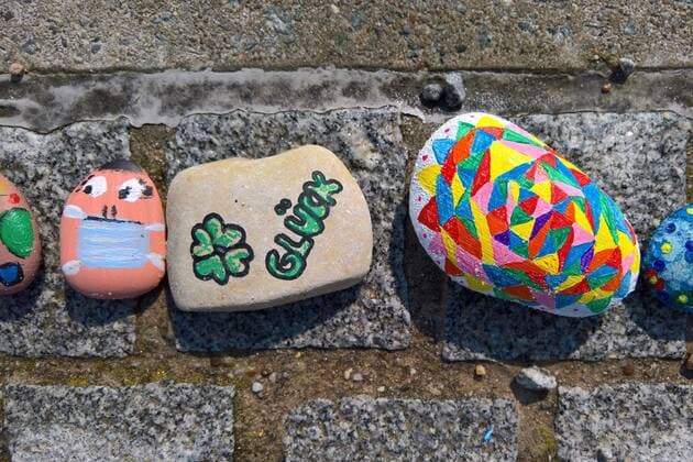In Regensburg children paint pebbles and lay them on the ground along the Danube near Schwabelweis After the Corona Pandemic people are allowed to help themselves and take their favourites home Photo Painted stones Face with mask, clover