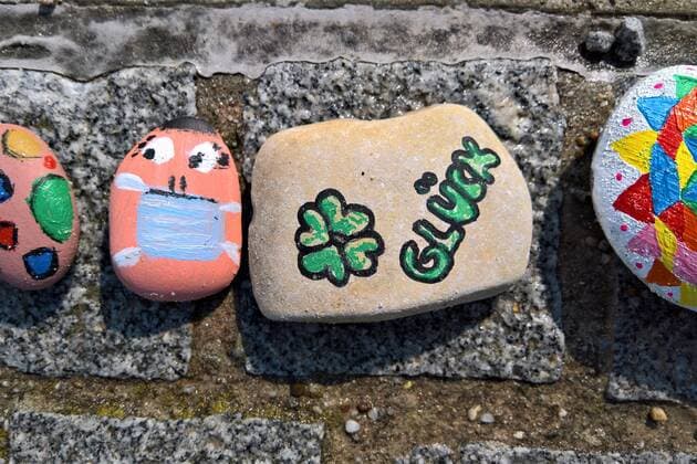 In Regensburg children paint pebbles and lay them on the ground along the Danube near Schwabelweis After the Corona Pandemic people are allowed to help themselves and take their favourites home with them Photo Painted stones Face with mask, lucky stone