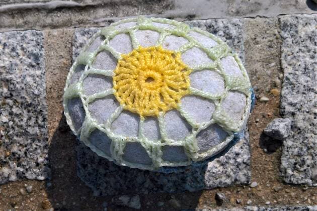 In Regensburg children paint stones and lay them on the ground along the Danube near Schwabelweis After the Corona Pandemic people are allowed to help themselves and take their favourites home with them Photo Crocheted wrapping of a stone