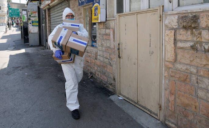 (200414) -- JERUSALEM, April 14, 2020 (Xinhua) -- An Israeli soldier wearing mask and protective gear distributes food packages to local citizens in the blocked Mea Shearim neighborhood in Jerusalem amid coronavirus pandemic on April 14, 2020. (Photo by Gil Cohen Magen Xinhua) MIDEAST-JERUSALEM-COVID-19-FOOD DISTRIBUTION 