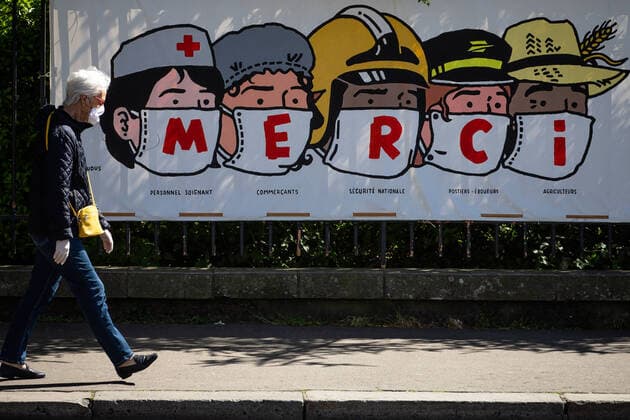 (200414) -- PARIS, April 14, 2020 (Xinhua) -- A resident walks past a poster thanking people in various professions during the epidemic in Paris, France, on April 14, 2020. (Photo by Aurelien Morissard Xinhua) FRANCE-PARIS-CORONAVIRUS-POSTER 