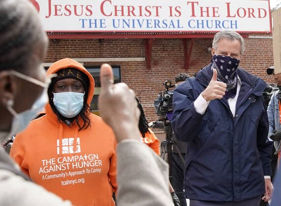 New York Mayor Bill de Blasio gives a thumbs up to workers when he visits The Campaign Against Hunger food pantry in New York City on Tuesday, April 14, 2020. As of today nearly 285,000 have been infected and more than 14,000 people have died in NY, NJ and CT. There are signs however that the curve is flattening.  NYP20200414101 JOHNxANGELILLO
