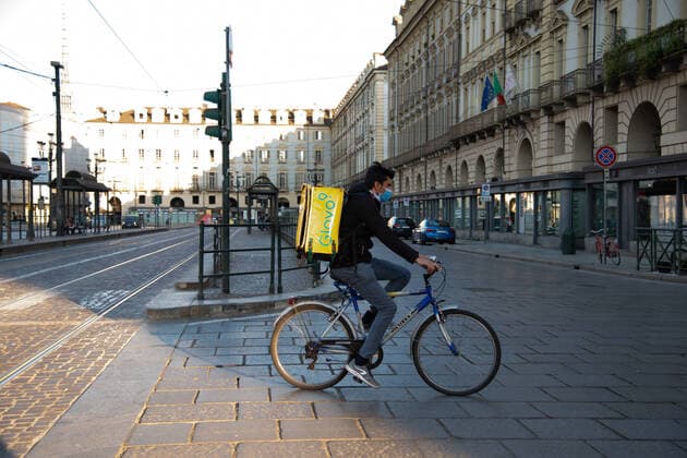 Italy: Turin lockdown 14th April 2020 An delivery man wearing an safety mask in Piazza Castello in a deserted Turin during the country s lockdown aimed at curbing the spread of the COVID-19 infection, caused by the novel coronavirus. Turin Piedmont Turin Italy Copyright: AlbertoxGandolfo