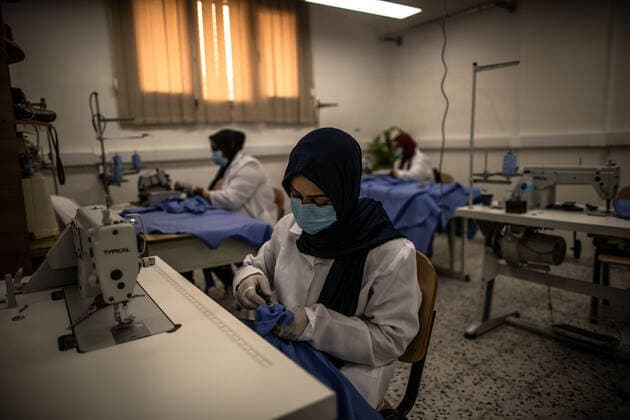 (200415) -- TRIPOLI, April 15, 2020 (Xinhua) -- A worker cuts fabric to make protective suits in a fashion school which was turned into a workshop producing protective gears in Tripoli, Libya, on April 14, 2020. The Libyan National Center for Disease Control on Tuesday announced nine new COVID-19 cases, bringing the total number of confirmed cases in the country to 35. (Photo by Amru Salahuddien Xinhua) LIBYA-TRIPOLI-COVID-19-PROTECTIVE WORKSHOP 