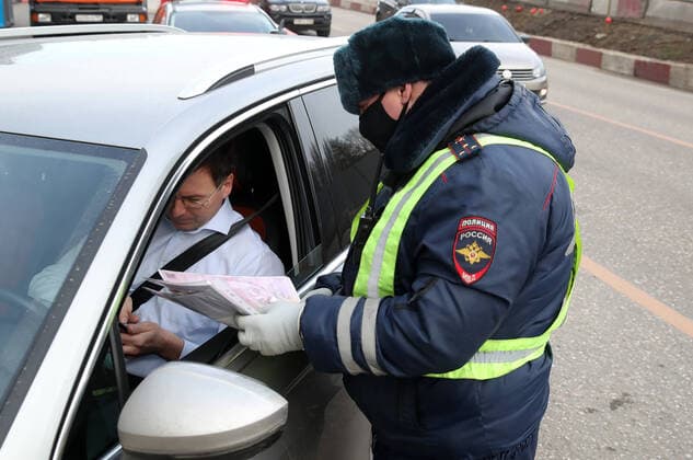 MOSCOW, RUSSIA - APRIL 15, 2020: A traffic police officer carries out an ID check during the pandemic of the novel coronavirus disease (COVID-19). Traffic police have set up checkpoints around the city to stop vehicles and see if drivers have permission to travel during the lockdown. On 13 April 2020, the Moscow government introduced a digital permit system aimed at further restricting movement. Under the new scheme, which becomes mandatory from 15 April, people need to apply for permits to travel on a vehicle or public transport around the city. Earlier, on 11 April, the Moscow government restricted vehicles registered outside Moscow Region from entering the Russian capital. Since 31 March 2020, Moscow has been on lockdown. As of 15 April 2020, Russia has reported more than 21,100 confirmed cases of the novel coronavirus infection, with TS0D5C61