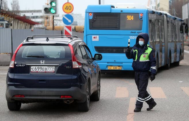 MOSCOW, RUSSIA - APRIL 15, 2020: A traffic police officer carries out ID checks on Volokolamskoye Shosse Motorway during the pandemic of the novel coronavirus disease (COVID-19). Traffic police have set up checkpoints around the city to stop vehicles and see if drivers have permission to travel during the lockdown. On 13 April 2020, the Moscow government introduced a digital permit system aimed at further restricting movement. Under the new scheme, which becomes mandatory from 15 April, people need to apply for permits to travel on a vehicle or public transport around the city. Earlier, on 11 April, the Moscow government restricted vehicles registered outside Moscow Region from entering the Russian capital. Since 31 March 2020, Moscow has been on lockdown. As of 15 April 2020, Russia has reported more than 21,100 confirmed cases of the no TS0D5C66
