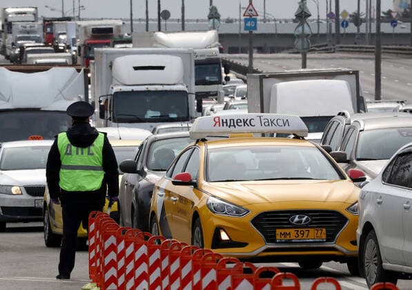MOSCOW, RUSSIA - APRIL 15, 2020: A traffic police officer stands guard on Volokolamskoye Shosse Motorway during the pandemic of the novel coronavirus disease (COVID-19). Traffic police have set up checkpoints around the city to stop vehicles and see if drivers have permission to travel during the lockdown. On 13 April 2020, the Moscow government introduced a digital permit system aimed at further restricting movement. Under the new scheme, which becomes mandatory from 15 April, people need to apply for permits to travel on a vehicle or public transport around the city. Earlier, on 11 April, the Moscow government restricted vehicles registered outside Moscow Region from entering the Russian capital. Since 30 March 2020, Moscow has been on lockdown. As of 15 April 2020, Russia has reported more than 21,100 confirmed cases of the novel coron TS0D5C9F