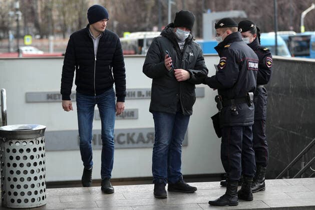 MOSCOW, RUSSIA - APRIL 15, 2020: A commuter in a face mask shows a digital code on his smartphone to police officers during an ID check at the entrance to Kiyevskaya Station of the Moscow Underground (metro) during the pandemic of the novel coronavirus disease (COVID-19). On 13 April 2020, the Moscow government introduced a digital permit system aimed at further restricting movement. Under the new scheme, which becomes mandatory from 15 April, people need to apply for permits to travel on public transport or a vehicle around the city. Since 30 March 2020, Moscow has been on lockdown. As of 15 April 2020, Russia has reported more than 21,100 confirmed cases of the novel coronavirus infection, with more than 13,000 confirmed cases in Moscow. Mikhail Tereshchenko TASS TS0D5CCF