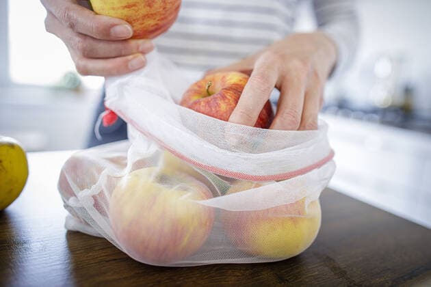Symbolfoto unverpackte Lebensmittel. Aepfel sind in einem wiederverwendbarem Einkaufsnetz verpackt. Berlin, 11.04.2020. Berlin Deutschland *** Symbol photo unpackaged food Apples are packed in a reusable shopping net Berlin, 11 04 2020 Berlin Germany Copyright: xThomasxTrutschel photothekx