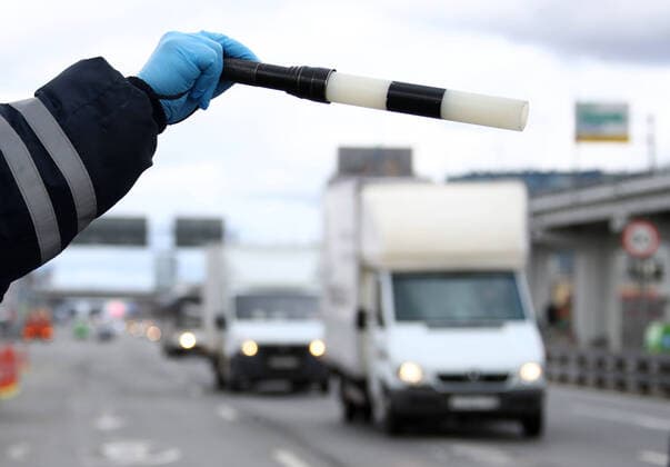 MOSCOW, RUSSIA - APRIL 15, 2020: A traffic police officer carries out ID checks on Leningradskoye Shosse Motorway at the entrance to Moscow during the pandemic of the novel coronavirus disease (COVID-19). Traffic police have set up checkpoints around the city to stop vehicles and see if drivers have permission to travel during the lockdown. On 13 April 2020, the Moscow government introduced a digital permit system aimed at further restricting movement. Under the new scheme, which becomes mandatory from 15 April, people need to apply for permits to travel on a vehicle or public transport around the city. Earlier, on 11 April, the Moscow government restricted vehicles registered outside Moscow Region from entering the Russian capital. Since 30 March 2020, Moscow has been on lockdown. As of 15 April 2020, Russia has reported more than 21,100 TS0D5CE2