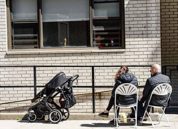 April 15, 2020, New York Manhattan, USA: Family members sitting in a chair on the sidewalk to visit family members sick with the coronavirus. Death toll in N.Y.10,367 as confirmed cases 106,813 04 15 20. New York Manhattan Randalls Island Icahn Stadium. New York Manhattan Upper East Side. New York Manhattan USA - ZUMAs252 20200415_znp_s252_004 Copyright: xMarcusxSantosx