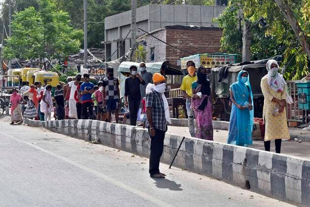 NEW DELHI, INDIA - APRIL 15: People stand queue for food distribute by Baba Gorakhnath Dhuna Ashram workers at slum people at NH 24 near mother dairy, on day twenty two of the 21-day nationwide lockdown on April 15, 2020 in New Delhi, India. (Photo by Sanjeev Verma Hindustan Times) Government Provide Food To Homeless And Poor Amid Lockdown To Prevent Covid-19