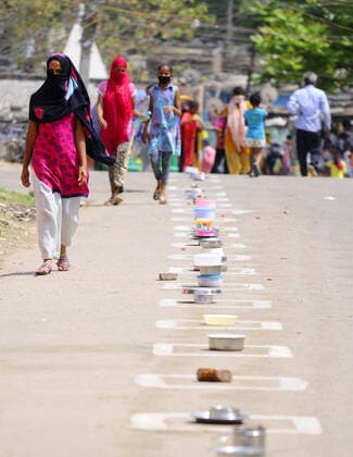 CHANDIGARH, INDIA - APRIL 15: People keep their utensils in the marked boxes as they wait at a food distribution during lockdown against Coronavirus, at a slum, in Industrial area Phase 1 on April 15, 2020 in Chandigarh, India. (Photo by Anil Dayal Hindustan Times) Government Provide Food To Homeless And Poor Amid Lockdown To Prevent Covid-19