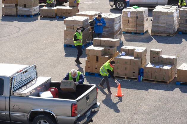 April 15, 2020, Austin, Texas, USA: Central Texas Food Bank volunteers work to load 28-pound boxes of staples into vehicles during a food giveaway in east Austin. Almost 2,500 families picked up boxes in response to extensive coronavirus pandemic job losses and general Texas economic fallout Austin USA - ZUMAd150 20200415_znp_d150_041 Copyright: xBobxDaemmrichx