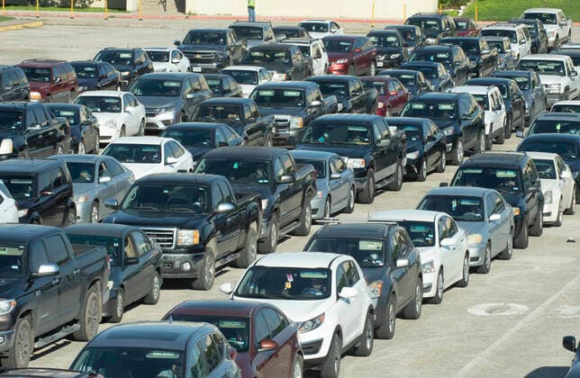 April 15, 2020, Austin, Texas, USA: Central Texas Food Bank volunteers survey people in long lines of cars as they later receive 28-pound boxes of staples during food giveaway in east Austin. Almost 2,500 families picked up boxes in response to extensive coronavirus pandemic job losses and general Texas economic fallout Austin USA - ZUMAd150 20200415_znp_d150_030 Copyright: xBobxDaemmrichx