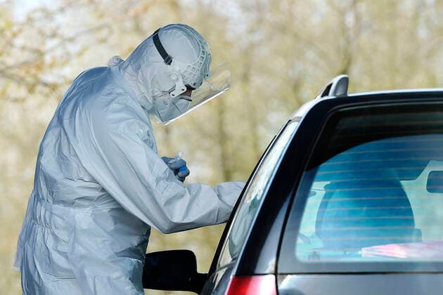 Paramedics take samples for covid-19 tests in drive-through testing station near the Domazlice Hospital, Czech Republic, on Wednesday, April 15, 2020. (CTKxPhoto MiroslavxChaloupka) CTKPhotoP202004150452901 cha007