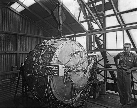 World War II photograph of the Trinity Test bomb, nicknamed the Gadget. The device is partially assembled on the test tower and Norris Bradbury looks on, July 1945. Copyright: JohnxParrot StocktrekxImages JPA500150A