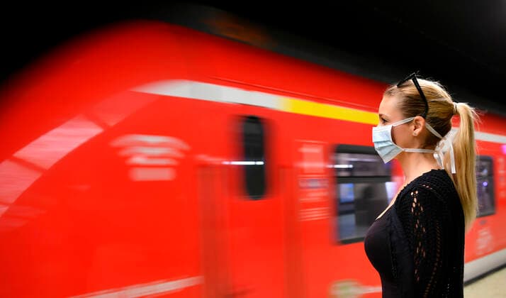 Woman with face mask, waiting for train, S Bahn, Corona crisis, Stuttgart, Baden Württemberg, Germany Coronavirus