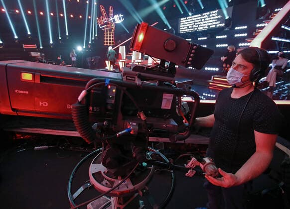 MOSCOW, RUSSIA - APRIL 17, 2020: A cameraman filming a live broadcast of an episode of The Voice Kids Russia reality television singing competition. The show is shot without audience amid the COVID-19 coronavirus pandemic. Vyacheslav Prokofyev TASS  TS0D62BF