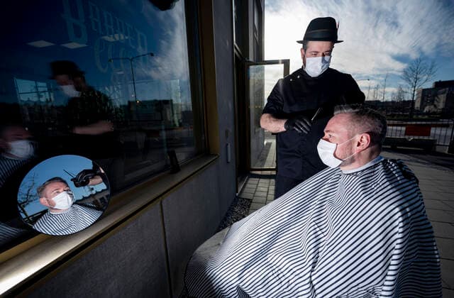 Hairdresser Abed Khankan at Barberesso in Malmo, Sweden cuts a customers hair outdoors as a procaution during the coronavirus pandemic April 17, 2020 MALMÖ Sweden x50090x,  Copyright: xJohanxNilsson TTx CUTTING HAIR OUTDOORS SWEDEN