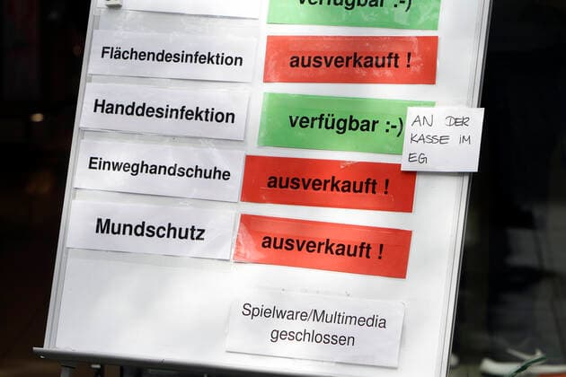 Sign with inscription mouthguard, disposable gloves and surface disinfectant sold out and hand disinfection available in front of a branch of the drugstore chain dm in the city centre of Mannheim, Baden Württemberg, Germany