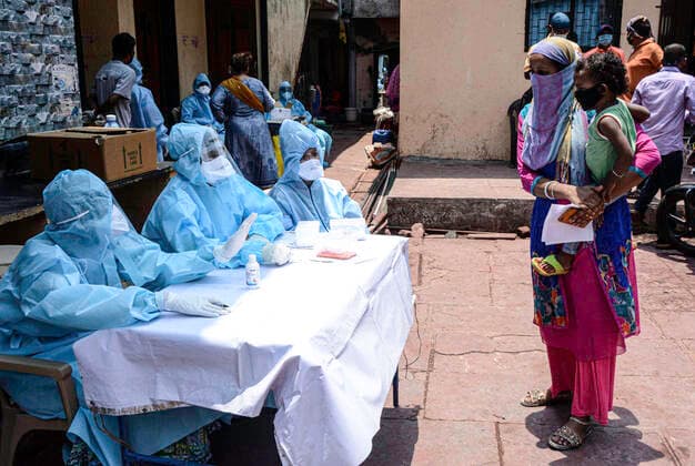 (200420) -- MUMBAI, April 20, 2020 (Xinhua) -- Medical staff in personal protective equipment wait to conduct novel coronavirus tests for people at Dharavi, Asia s largest slum, in Mumbai, India, April 18, 2020. (Str Xinhua) INDIA-MUMBAI-DHARAVI SLUM-CORONAVIRUS TEST 