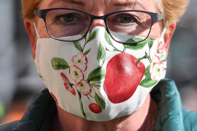 Masks in Bavaria in all shops and in public transport Masks in all variations are now part of everyday life in times of Corona A self-sewn, reusable face mask, mouth mask, mouth nose protection of a woman shows floral patterns and a red cherry