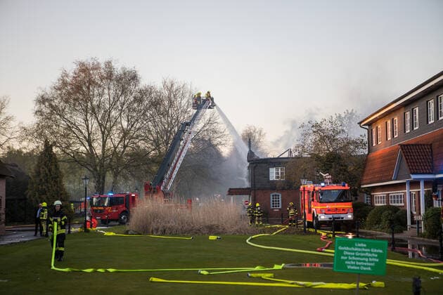 Großbrand auf Golfplatz in Prisdorf - Feuerwehr kann zwei große Reetdachhäuser retten! 21.04.20 - Prisdorf: Mehr als 100 Einsatzkräfte von fünf Freiwilligen Feuerwehren kämpfen aktuell gegen einen ausgedehnten Großbrand auf dem Gelände eines Golfplatzes in Prisdorf. Dort ist aus bislang noch ungeklärter Ursache ein kombiniertes Wohn- und Geschäftshaus in Brand geraten. Als die ersten Einsatzkräfte der Freiwilligen Feuerwehr Prisdorf wenige Minuten nach der um 18.41 Uhr erfolgten Alarmierung an der Einsatzstelle eintrafen, stand das Gebäude bereits in Vollbrand. Daher ließ der Einsatzleiter umgehend weitere Kräfte nachalarmieren. Die Brandbekämpfung erfolgt ausschließlich von außen über mehrere handgeführte Strahlrohre sowie über die Drehleiter der Freiwilligen Feuerwehr Pinneberg. Schwierigkeiten machte in der Anfa Copyright: xSebastianxPetersx