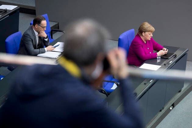 Angela Merkel - Bundestag, Coronavirus Crisis DEU, Deutschland, Germany, Berlin, 23.04.2020 Fotograf mit Schutzmaske und Heiko Maas, Bundesaussenminister SPD, und Angela Merkel, Bundeskanzlerin CDU, auf der Regierungsbank waehrend der Plenarsitzung zum Thema Regierungserklaerung und Reaktion auf die Corona-Krise im Plenarsaal Deutscher Bundestag in Berlin. Photographer with protection mask and Heiko Maas, Federal Minister for Foreign Affairs SPD, and Angela Merkel, Chancellor CDU (f.l.t.r.), during a debate at a session of the German parliament Deutscher Bundestag concerning the novel coronavirus crisis in Berlin on April 23, 2020, Germany. Only every third chair was available to the MP s in the chamber to mainitain social distancing during the debate as Germany enforces a partial lockdown trying to slow down the spread of the novel coron