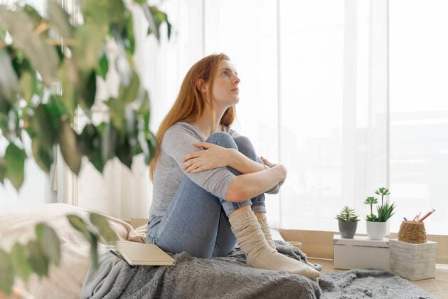 Serious young woman at home looking up model released Symbolfoto property released AFVF06014