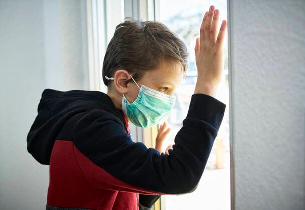 Sad boy with mask looking out of window model released Symbolfoto property released DIKF00407