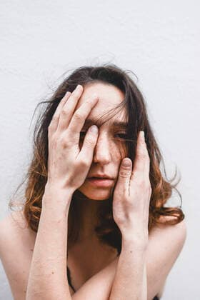 Portrait of depressed young woman with hands on her face model released Symbolfoto FVSF00058