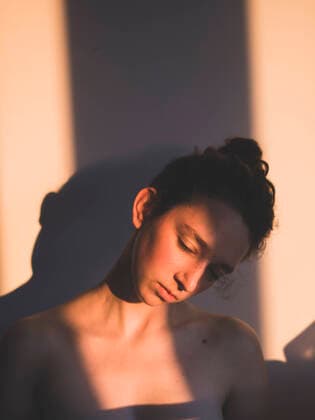 Portrait of naked woman with closed eyes during sunrise at home model released Symbolfoto FVSF00094