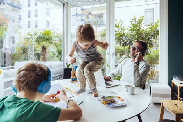 Father talking on the phone while sons are playing on the table model released Symbolfoto property released MFF05177