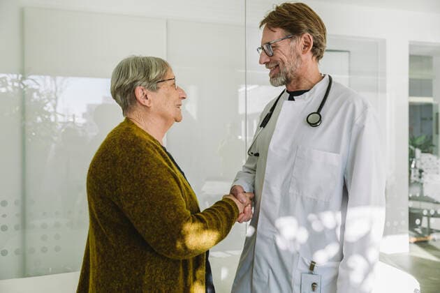 Doctor and senior patient in medical practice shaking hands model released Symbolfoto property released MFF05423
