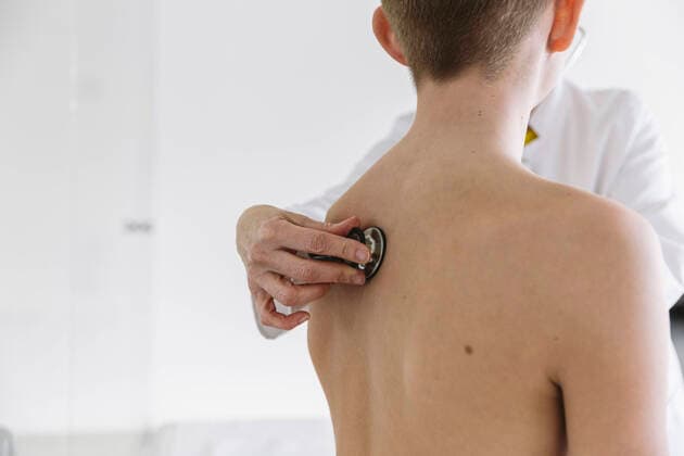 Doctor examining teenage boy with a stethoscope model released Symbolfoto property released MFF05507