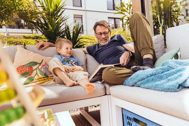 Father and son reading a book on their terrace model released Symbolfoto property released MFF05556